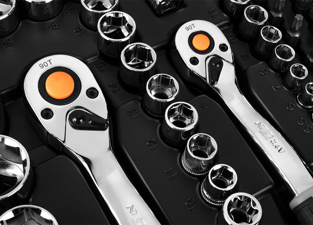 Na obrazie widoczne są dwa chromowane klucze nasadowe z pomarańczowymi przyciskami oraz zestaw nasadek o różnych rozmiarach. Na jednym z kluczy widoczny jest napis \'NEO TOOLS\'.