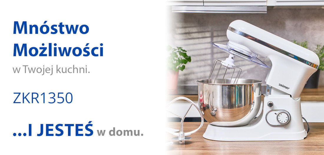 Obraz przedstawia biały robot planetarny z metalową misą na blacie kuchennym. Po lewej stronie widoczny jest tekst: \'Mnóstwo Możliwości w Twojej kuchni. ZKR1350 ...I JESTEŚ w domu.\'