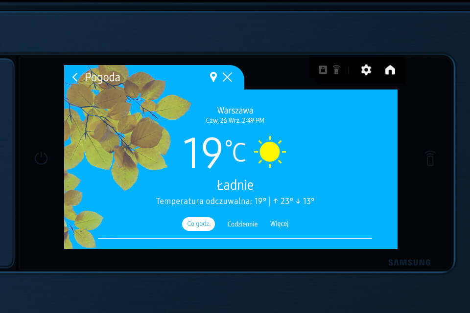 Ekran pralki pokazuje prognozę pogody dla Warszawy z temperaturą 19°C i ikoną słońca. Widoczny jest tekst: \'Ładnie, Temperatura odczuwalna: 19° | ↑ 23° ↓ 13°\'.