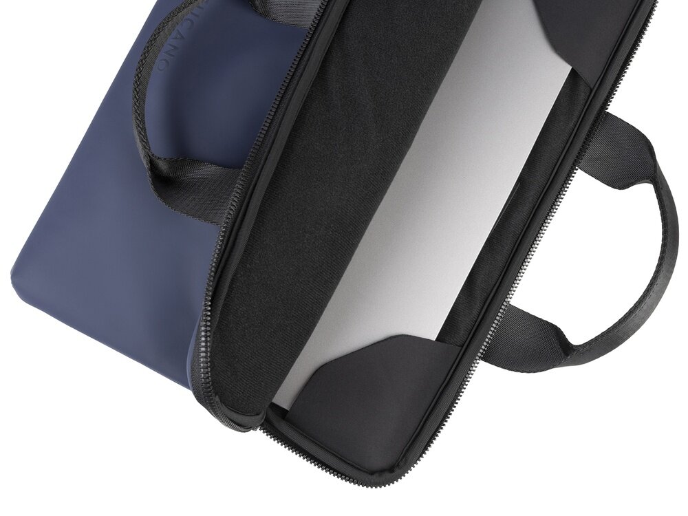 Niebieska torba na laptopa z czarnymi uchwytami i zamkiem błyskawicznym, częściowo otwarta, ukazująca wnętrze z miejscem na laptopa. Na torbie widoczne jest wytłoczone logo \'TUCANO\'.