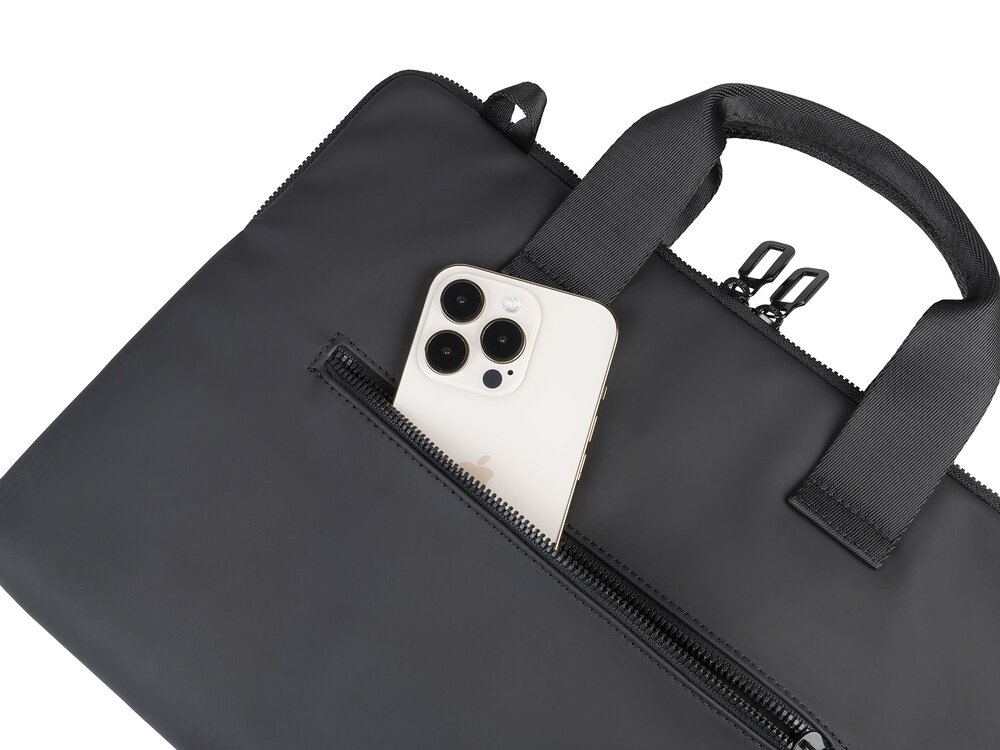 Czarne etui na laptopa z zamkiem błyskawicznym, z którego wystaje smartfon. Etui posiada dwa uchwyty do przenoszenia.