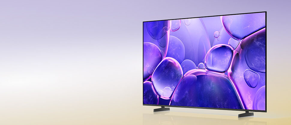 970x415 u8000f kv pc Telewizor z cienką ramką wyświetla obraz z fioletowymi i różowymi bąbelkami na ekranie. Tło jest gradientowe, przechodzące od fioletu do jasnego beżu.