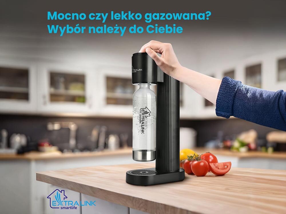 Osoba używa czarnego saturatora EXTRALINK SmartLife Hydrospark SJ-191B w kuchni. Na obrazie widoczny jest tekst: \'Mocno czy lekko gazowana? Wybór należy do Ciebie\'.