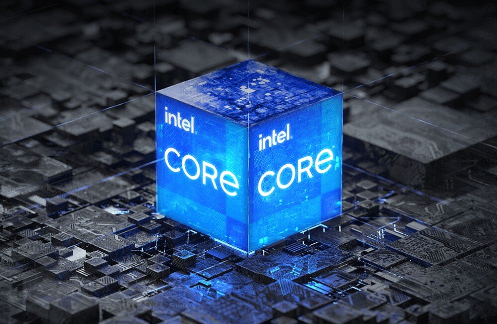 Na obrazie widoczny jest niebieski sześcian z napisem \'intel CORE\', umieszczony na tle przypominającym układ scalony.