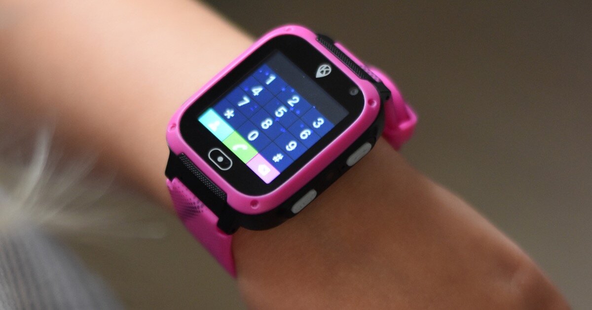 Różowy smartwatch z kolorowym wyświetlaczem na nadgarstku, z widocznymi ikonami aplikacji i białymi przyciskami po bokach.