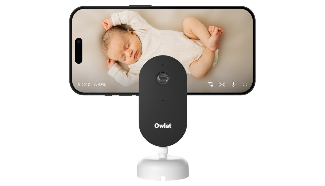 Na obrazie widoczna jest elektroniczna niania z ekranem, na którym pokazane jest śpiące dziecko. Na urządzeniu znajduje się logo \'Owlet\'.