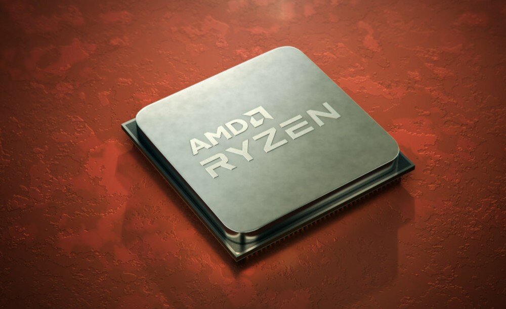 Na obrazie widoczny jest procesor z napisem \'AMD RYZEN\' na metalicznej powierzchni, umieszczony na czerwonym tle.