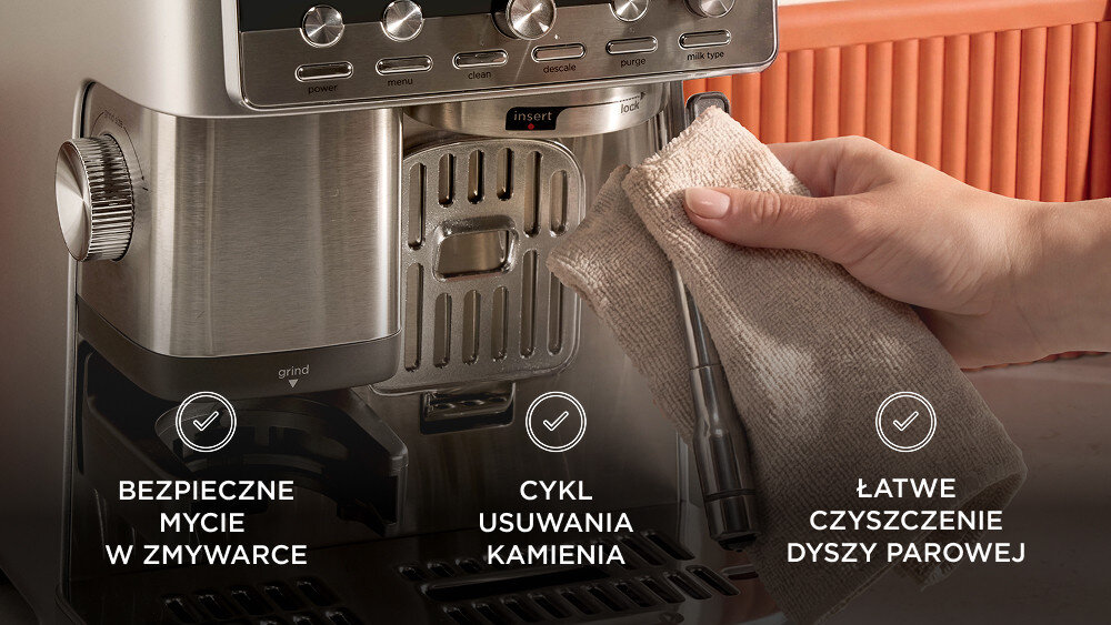 Na zdjęciu widoczny jest ekspres do kawy z metalicznymi elementami oraz ręka trzymająca ściereczkę przy dyszy parowej. Na obrazie znajdują się napisy: \'BEZPIECZNE MYCIE W ZMYWARCE\', \'CYKL USUWANIA KAMIENIA\', \'ŁATWE CZYSZCZENIE DYSZY PAROWEJ\'.