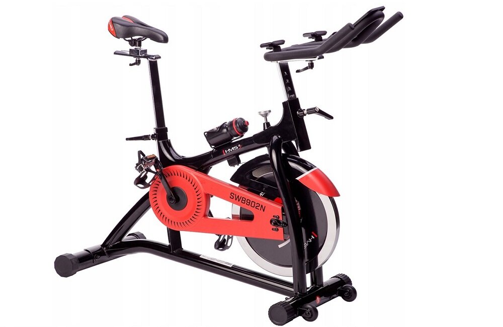 Rower spinningowy w kolorze czarno-czerwonym z widocznym napisem \'SW8902N\'. Posiada regulowane siodełko i kierownicę oraz koło zamachowe z przodu.