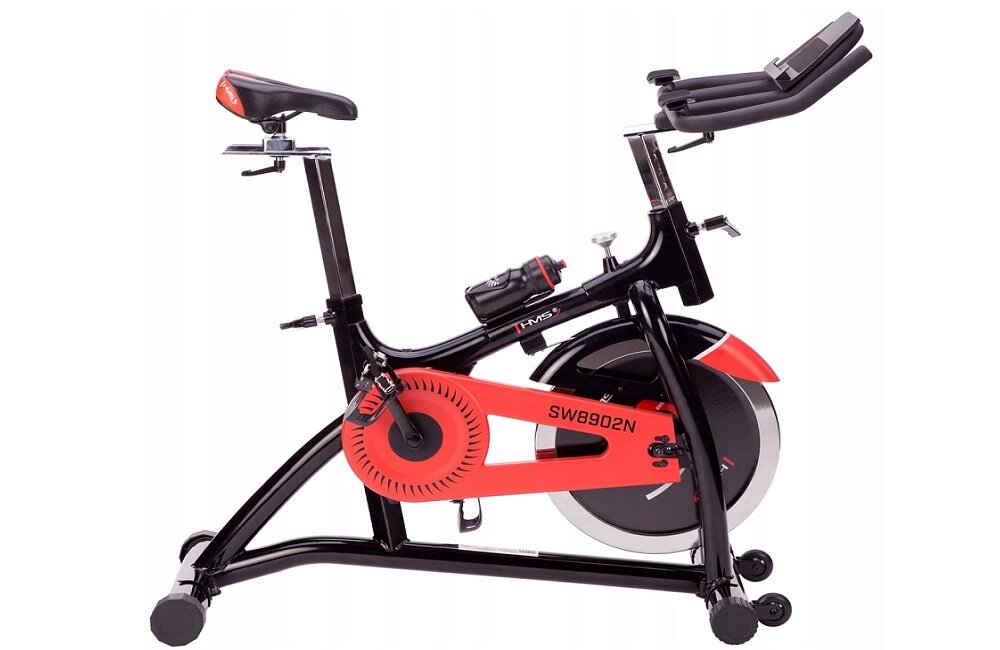 Rower spinningowy w kolorze czarno-czerwonym z oznaczeniem SW8902N na ramie. Posiada regulowane siodełko, uchwyty oraz koło zamachowe z osłoną.