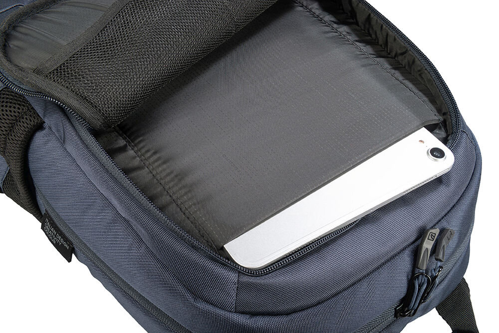 Otwarty plecak w kolorze niebieskim z widoczną kieszenią na laptopa, w której znajduje się urządzenie elektroniczne. Wnętrze plecaka jest wyściełane ciemnym materiałem, a na zewnątrz widoczny jest zamek błyskawiczny.