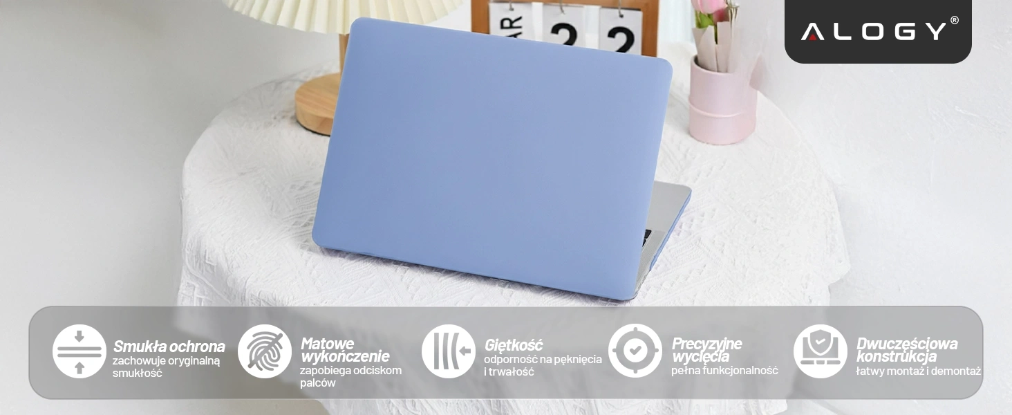 Na obrazie widoczny jest laptop z lawendowym etui na białym stole, obok którego stoi różowy wazon z kwiatami. W prawym górnym rogu znajduje się logo \'ALOGY\', a na dole widoczne są ikony z tekstem: \'Smukła ochrona\', \'Matowe wykończenie\', \'Giętkość\', \'Precyzyjne wycięcia\', \'Dwuczęściowa konstrukcja\'.