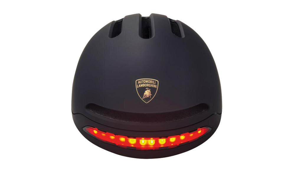 Czarny kask z logo \'AUTOMOBILI LAMBORGHINI\' i czerwonymi światłami LED na tylnej części.