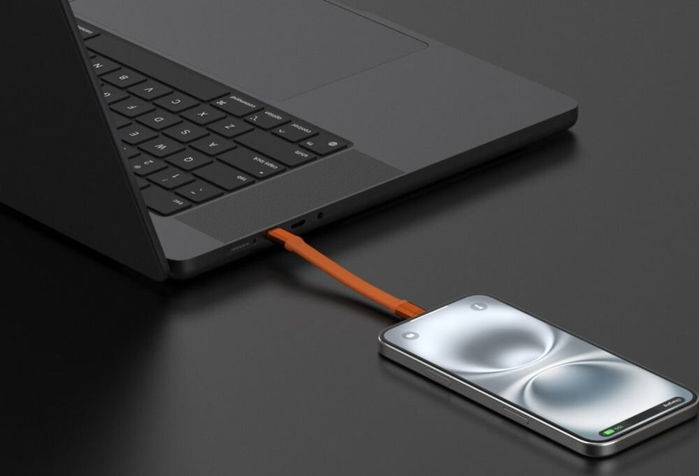 Na ciemnym tle widać laptopa z podłączonym pomarańczowym kablem USB-C do smartfona. Ekran smartfona jest włączony i wyświetla abstrakcyjny wzór.