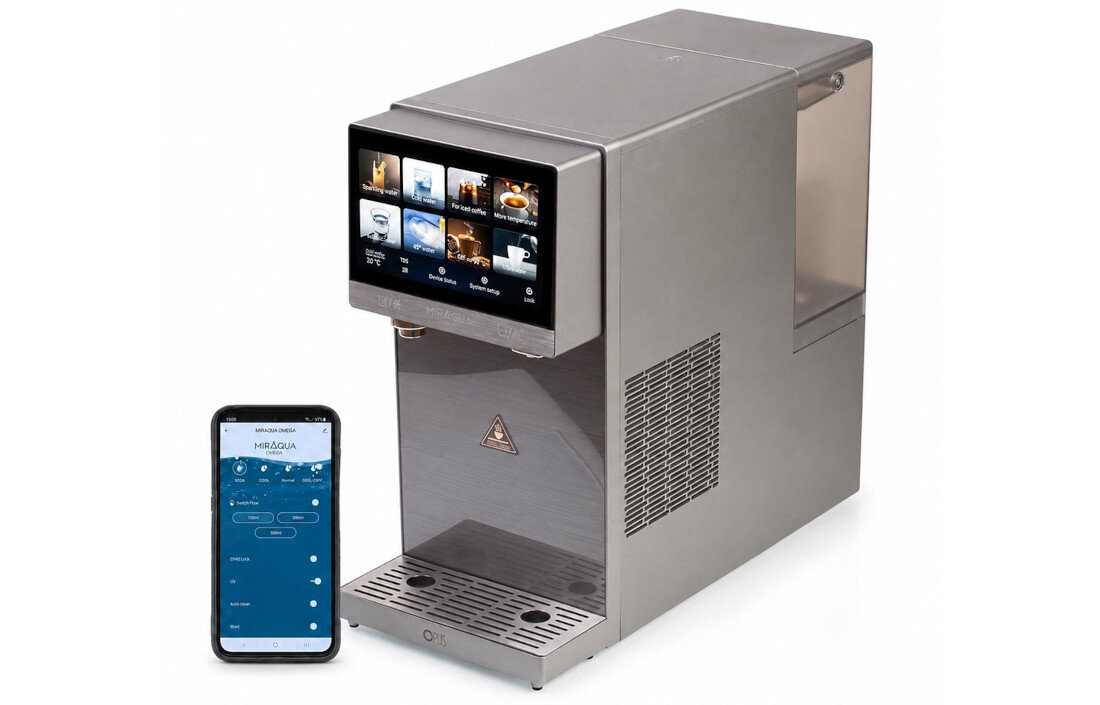 Na obrazie widoczny jest metalowy dystrybutor wody z ekranem dotykowym, na którym wyświetlane są różne ikony. Obok znajduje się smartfon z aplikacją Miraqua Omega na ekranie.