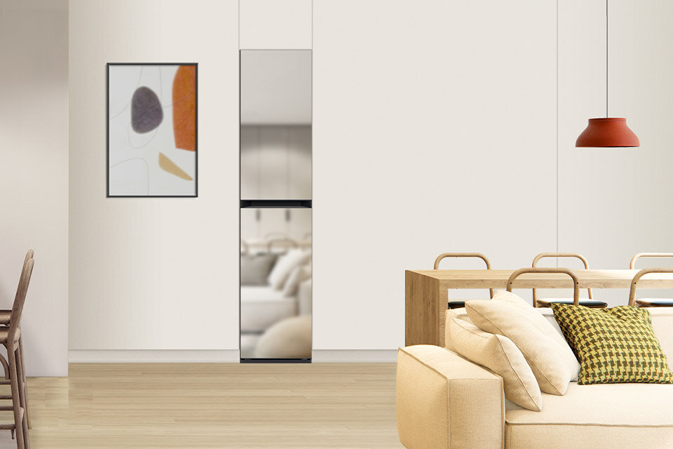 AirDresser Samsung DF18CB8700CRE1 Wnętrze nowoczesnego salonu z jasnymi ścianami, na których wisi abstrakcyjny obraz. W pomieszczeniu znajduje się kanapa z poduszkami, stół z krzesłami oraz lampa wisząca.
