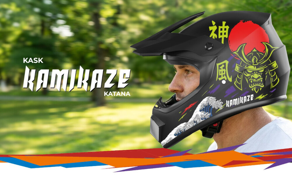 Czarny kask motocyklowy z grafiką samuraja i czerwonym słońcem, z napisem \'KAMIKAZE\' oraz japońskimi znakami. W tle zielony park, a na pierwszym planie widoczna jest część twarzy osoby noszącej kask.