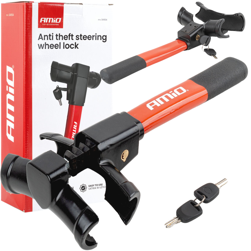 Na obrazie widoczna jest blokada kierownicy w kolorze czerwonym z czarnymi elementami oraz opakowanie z napisem \'AMiO Anti theft steering wheel lock\'. Obok znajdują się dwa klucze do blokady.
