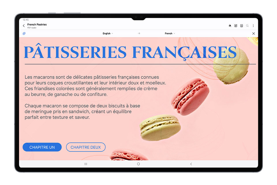 Tablet wyświetla stronę z tekstem w języku francuskim o makaronikach, z dużym nagłówkiem \'PÂTISSERIES FRANÇAISES\'. Na ekranie widoczne są także kolorowe makaroniki oraz przyciski \'CHAPITRE UN\' i \'CHAPITRE DEUX\'.