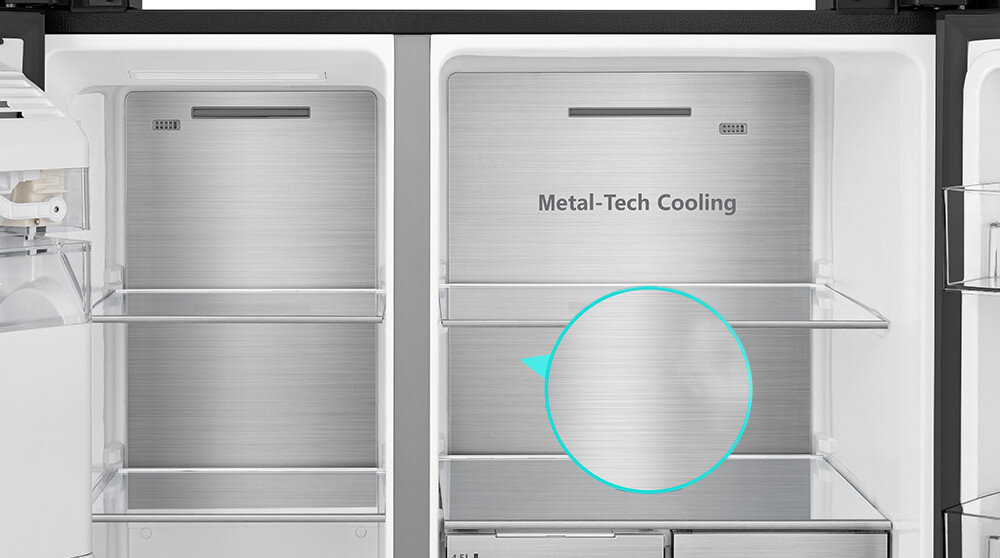 Wnętrze lodówki z metalowymi półkami i napisem \'Metal-Tech Cooling\' na tylnej ścianie. Po lewej stronie widoczna jest część kostkarki.