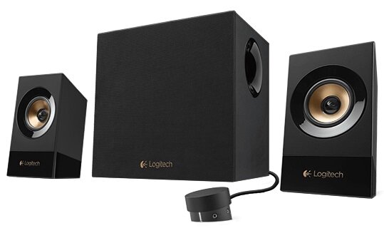 Na obrazie widoczne są czarne głośniki z logo \'Logitech\', w tym dwa mniejsze głośniki i jeden większy subwoofer. Obok znajduje się okrągły kontroler z przewodem.