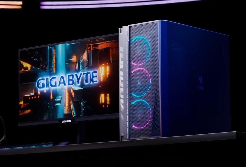 Komputer GIGABYTE Aorus Prime 5 Komputer stacjonarny stojący na biurku obok monitora z wyświetlanym napisem 'GIGABYTE'