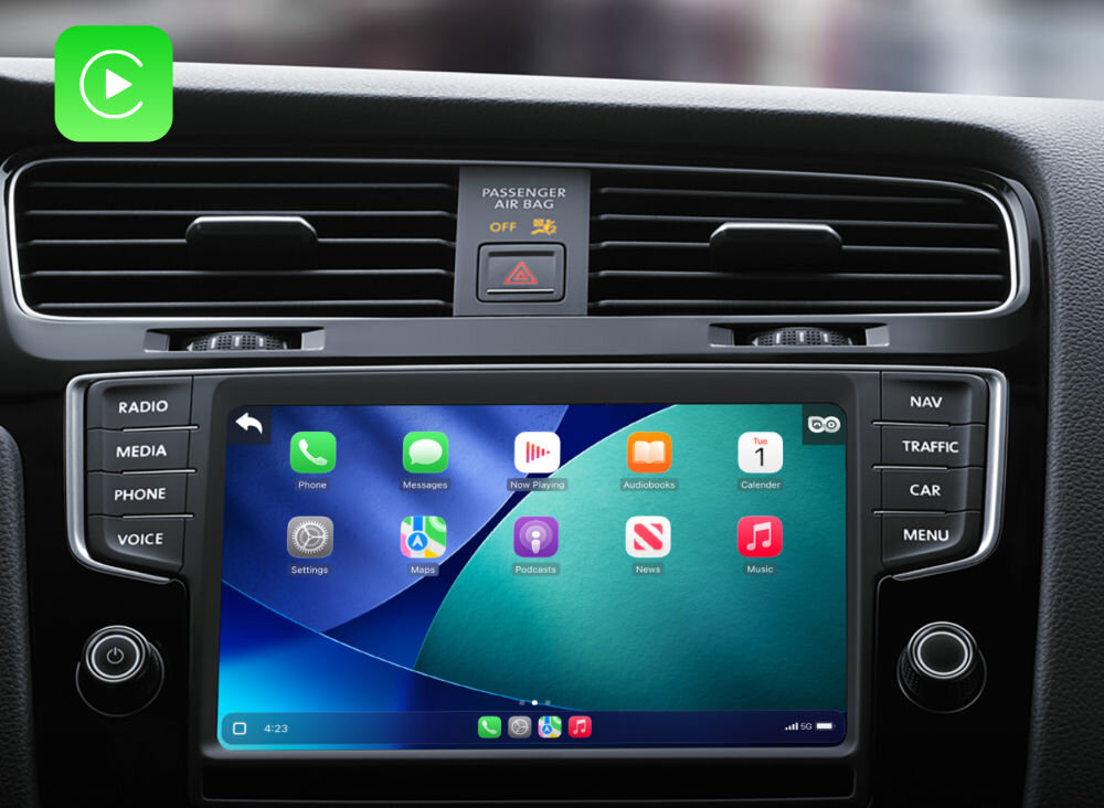 Wnętrze samochodu z widocznym ekranem dotykowym wyświetlającym interfejs CarPlay z ikonami aplikacji takimi jak Telefon, Wiadomości, Muzyka i Mapy. Nad ekranem znajduje się panel z napisem \'PASSENGER AIR BAG\'.
