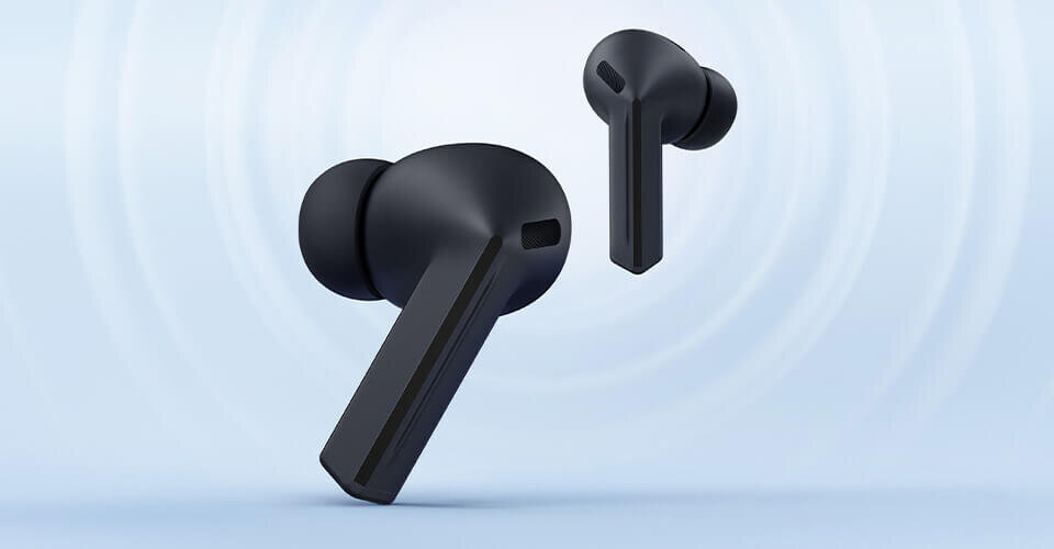 Lewa słuchawka Galaxy Buds3 FE w kolorze czarnym skierowana w lewo na pierwszym planie, prawa słuchawka lekko z tyłu skierowana w prawo. Na obrazie widoczne są czarne słuchawki dokanałowe na jasnym tle. Słuchawki mają nowoczesny design z wydłużonymi elementami.