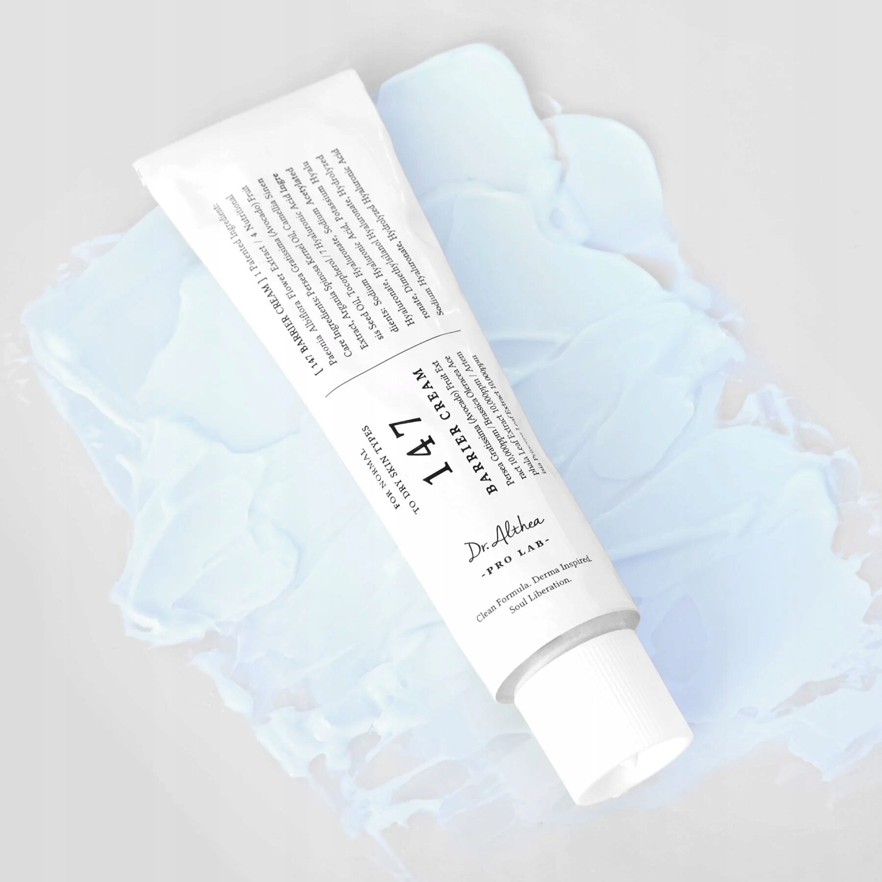 Na obrazie widoczna jest biała tubka z napisem \'147 BARRIER CREAM Dr. Althea PRO LAB\'. Tubka leży na jasnoniebieskim tle przypominającym rozsmarowany krem.
