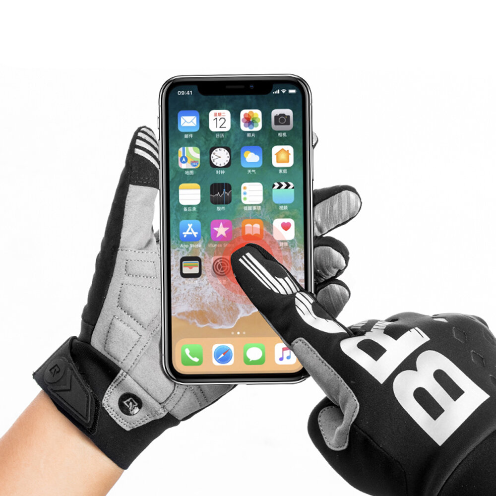 Dwie ręce w rękawiczkach rowerowych trzymają smartfon z widocznym ekranem głównym. Na ekranie znajdują się różne ikony aplikacji.