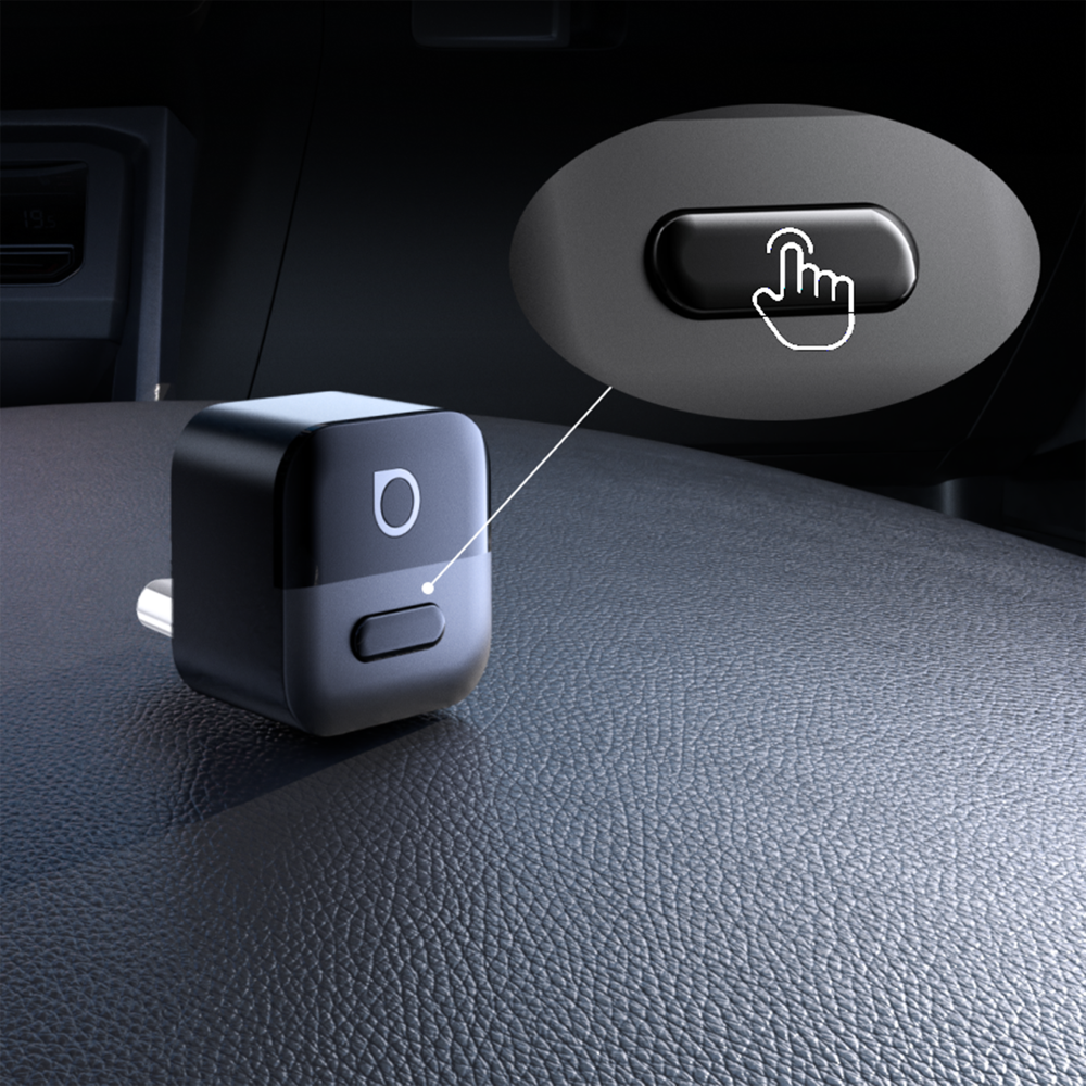 Na obrazie widoczny jest czarny adapter USB-C z przyciskiem i logo w kształcie litery \'O\'. Obok znajduje się powiększenie przycisku z ikoną dłoni wskazującą na jego naciśnięcie.