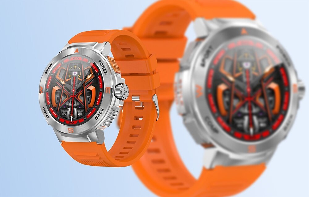 Obraz przedstawia smartwatch z pomarańczowym paskiem i srebrną kopertą. Tarcza zegarka ma skomplikowany wzór z elementami w kolorze czarnym i czerwonym.