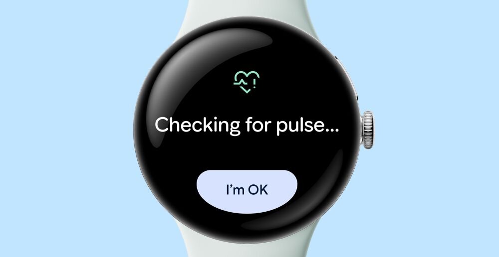 Smartwatch z okrągłym wyświetlaczem pokazuje tekst \'Checking for pulse...\' oraz przycisk \'I\'m OK\'.