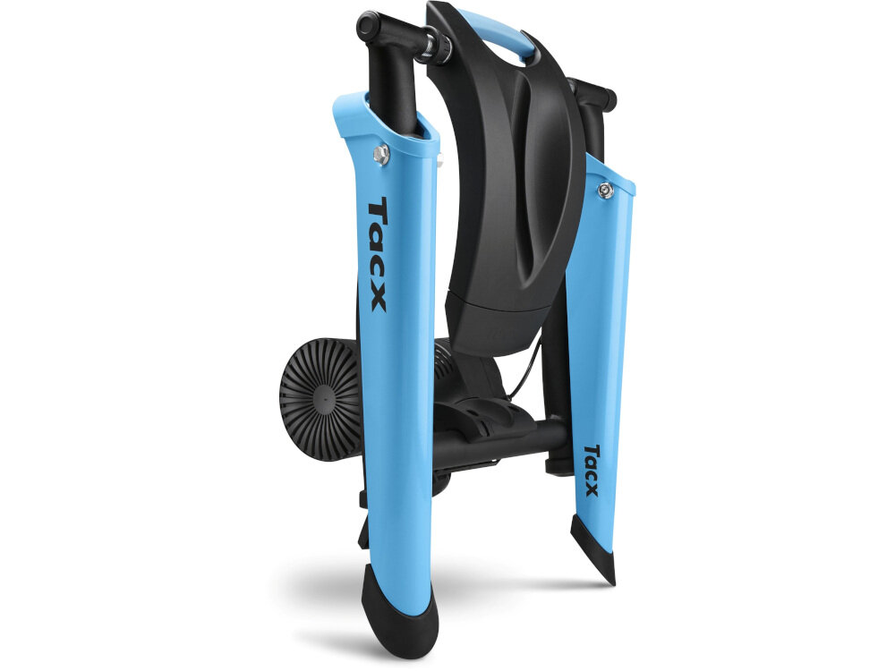 Na obrazie widoczny jest trenażer rowerowy z niebieskimi elementami i czarnymi detalami. Na niebieskich częściach znajduje się napis \'Tacx\'.