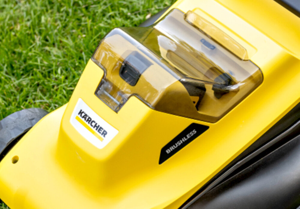 Zbliżenie na żółtą kosiarkę z widocznym logo \'KARCHER\' oraz napisem \'BRUSHLESS\'.