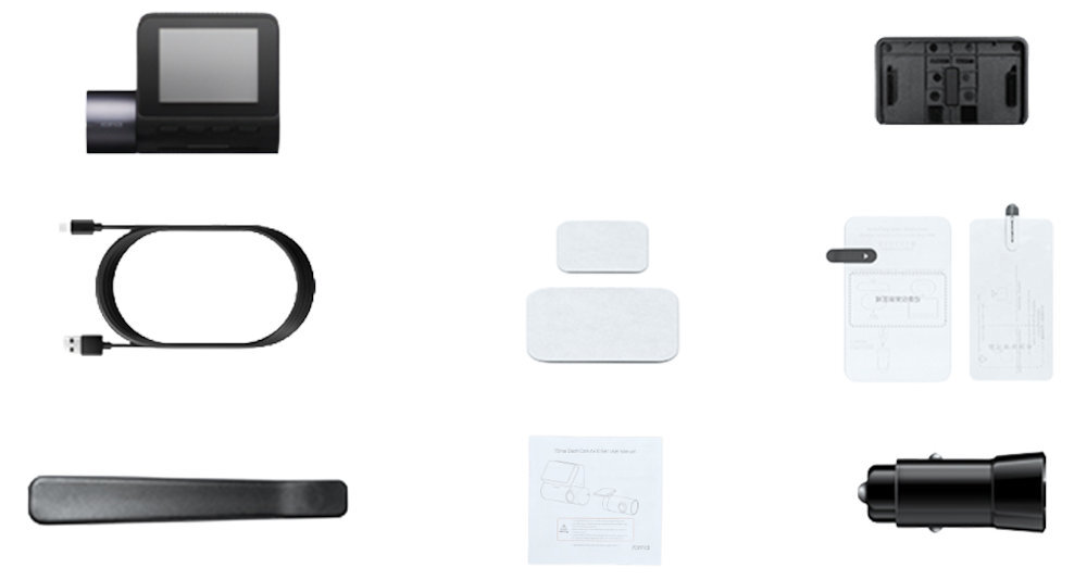 Na obrazie widoczny jest zestaw akcesoriów do wideorejestratora, w tym urządzenie z ekranem, kabel USB, uchwyt montażowy, ładowarka samochodowa, instrukcja obsługi oraz dwie prostokątne naklejki.