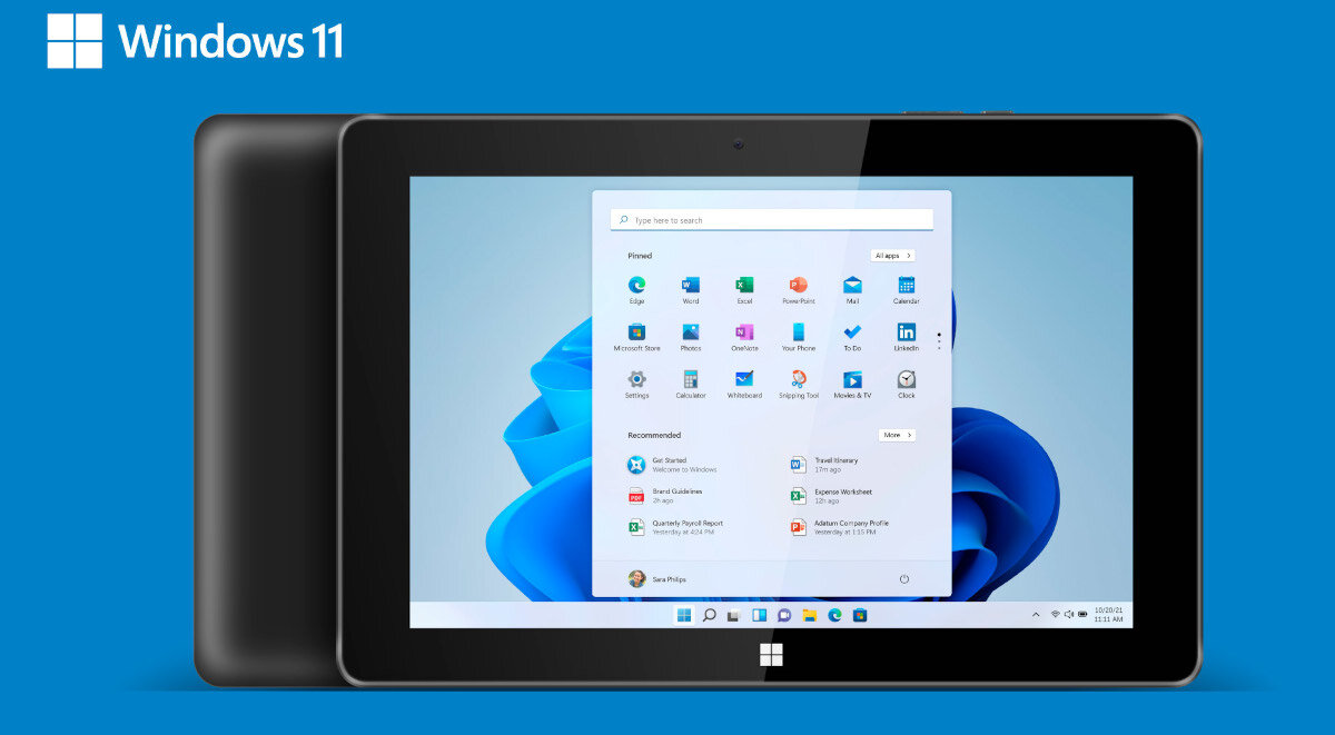 Na niebieskim tle widoczny jest tablet z systemem Windows 11, na ekranie którego wyświetlone są ikony aplikacji i menu startowe. W lewym górnym rogu znajduje się logo Windows 11.
