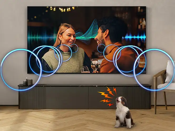 Na obrazie widać telewizor wyświetlający scenę z dwiema osobami, wokół których widoczne są niebieskie kręgi i fale dźwiękowe. Przed telewizorem stoi pies, a z jego pyska wychodzą pomarańczowe linie symbolizujące dźwięk.