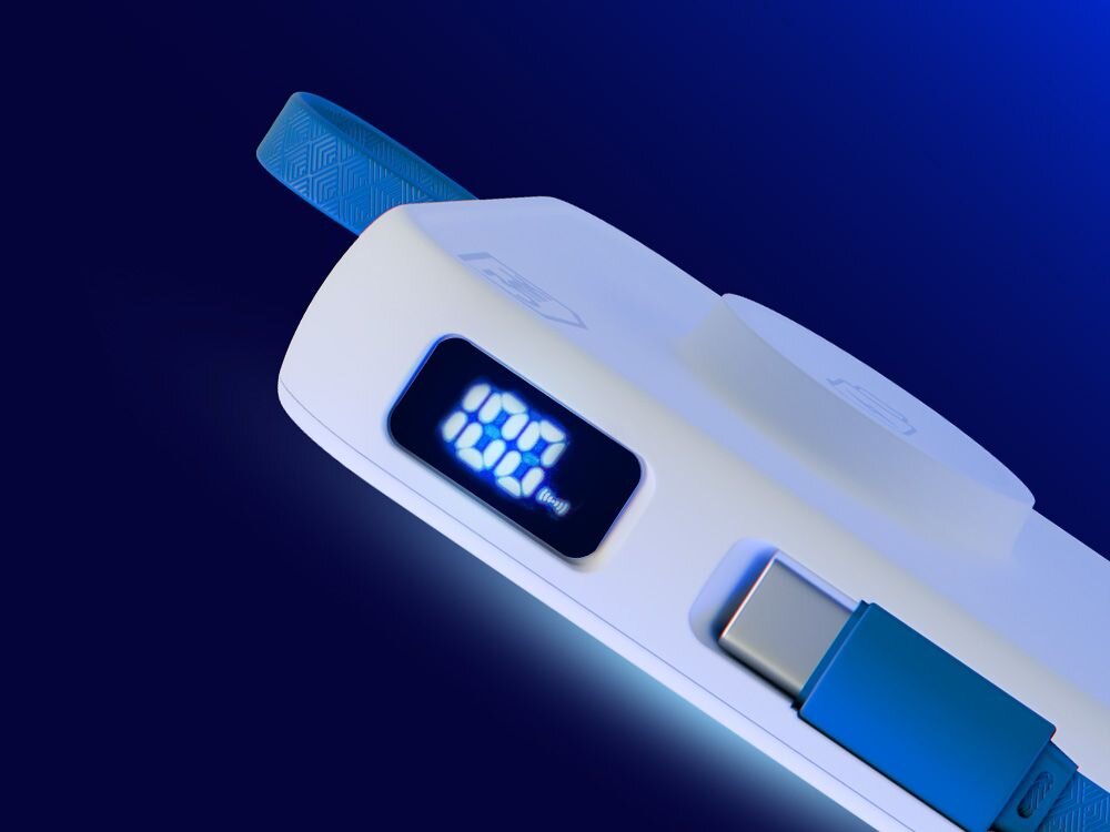 Na obrazie widoczny jest biały powerbank z wyświetlaczem LED pokazującym \'100%\'. Obok znajduje się niebieski kabel USB-C.