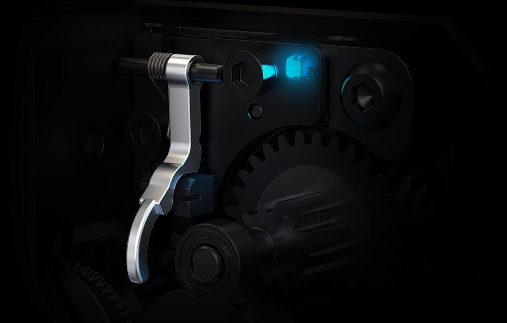 Obraz przedstawia mechanizm wewnętrzny z metalową dźwignią i zębatką, oświetlony niebieskim światłem LED. Widoczne są również śruby i elementy konstrukcyjne.