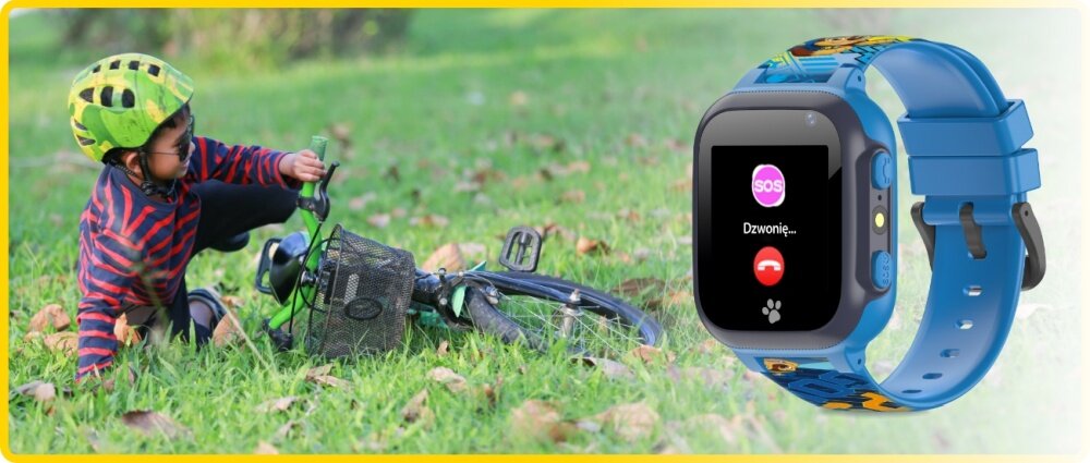 Na trawie leży przewrócony rower, obok którego siedzi dziecko w kasku. Obok widoczny jest niebieski smartwatch z wyświetlaczem pokazującym ikonę SOS i napis \'Dzwonię...\'.