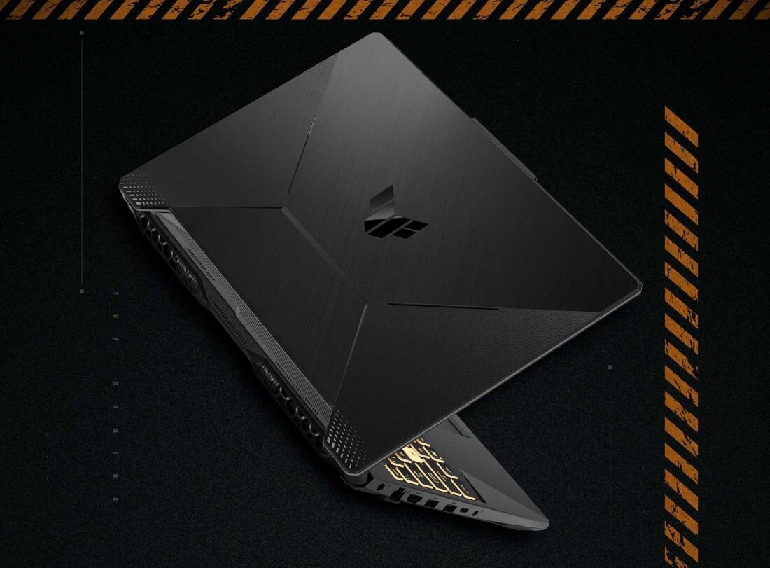 Czarny laptop z widocznym logo na pokrywie, ustawiony pod kątem na ciemnym tle z pomarańczowymi elementami dekoracyjnymi.