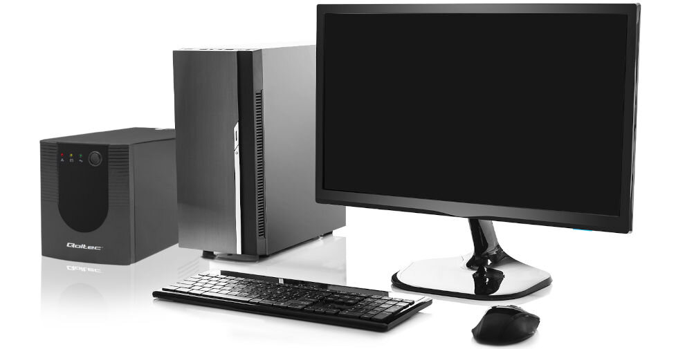 Na obrazie znajduje się zestaw komputerowy składający się z monitora, klawiatury, myszy, obudowy komputera oraz zasilacza UPS z widocznym logo \'Qoltec\'.