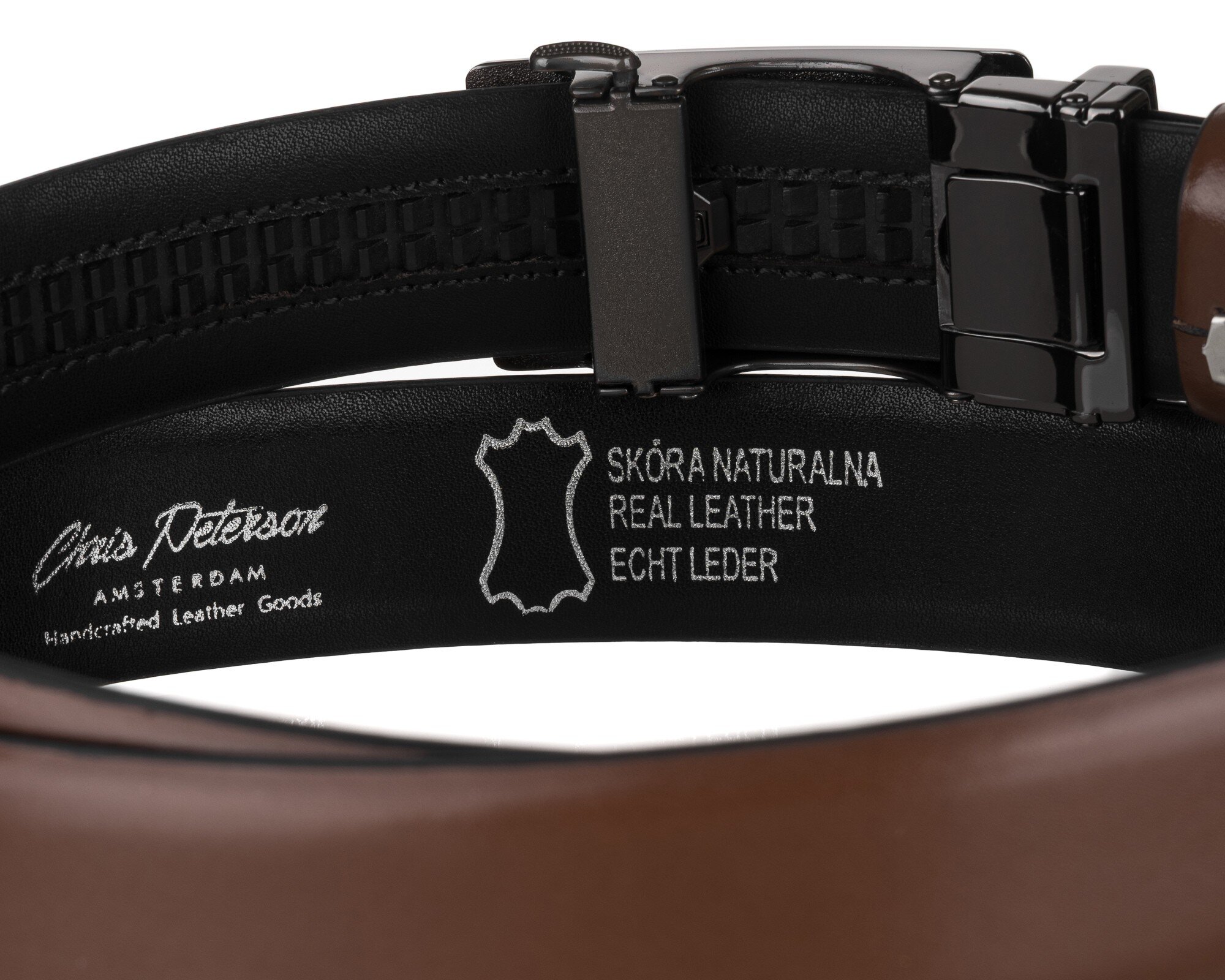 Brązowy pasek skórzany z automatyczną klamrą, na którym widnieje napis: \'Chris Peterson AMSTERDAM Handcrafted Leather Goods\' oraz \'SKÓRA NATURALNA REAL LEATHER ECHT LEDER\'.