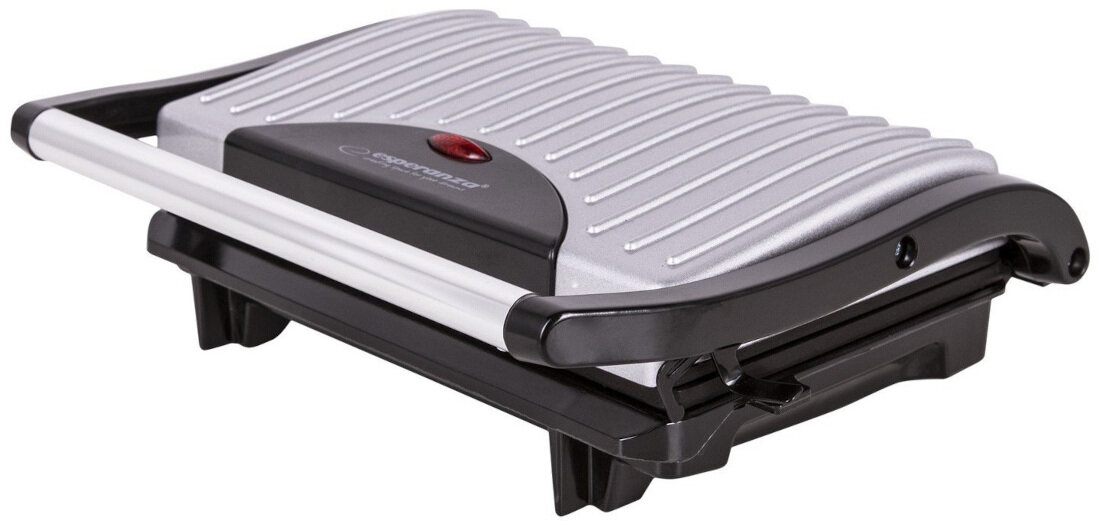 Grill elektryczny z metaliczną pokrywą z rowkami i czarnymi elementami. Na pokrywie widoczne jest logo \'esperanza\' oraz czerwona kontrolka.
