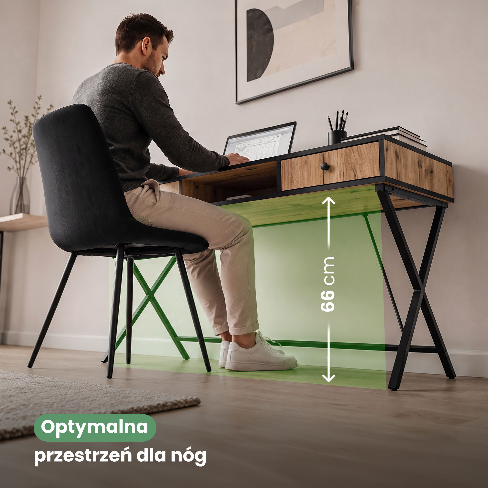 Osoba siedzi przy biurku z drewnianym blatem i czarnymi nogami, pracując na laptopie. Na obrazie widoczny jest tekst: \'Optymalna przestrzeń dla nóg\' oraz oznaczenie wysokości 66 cm.