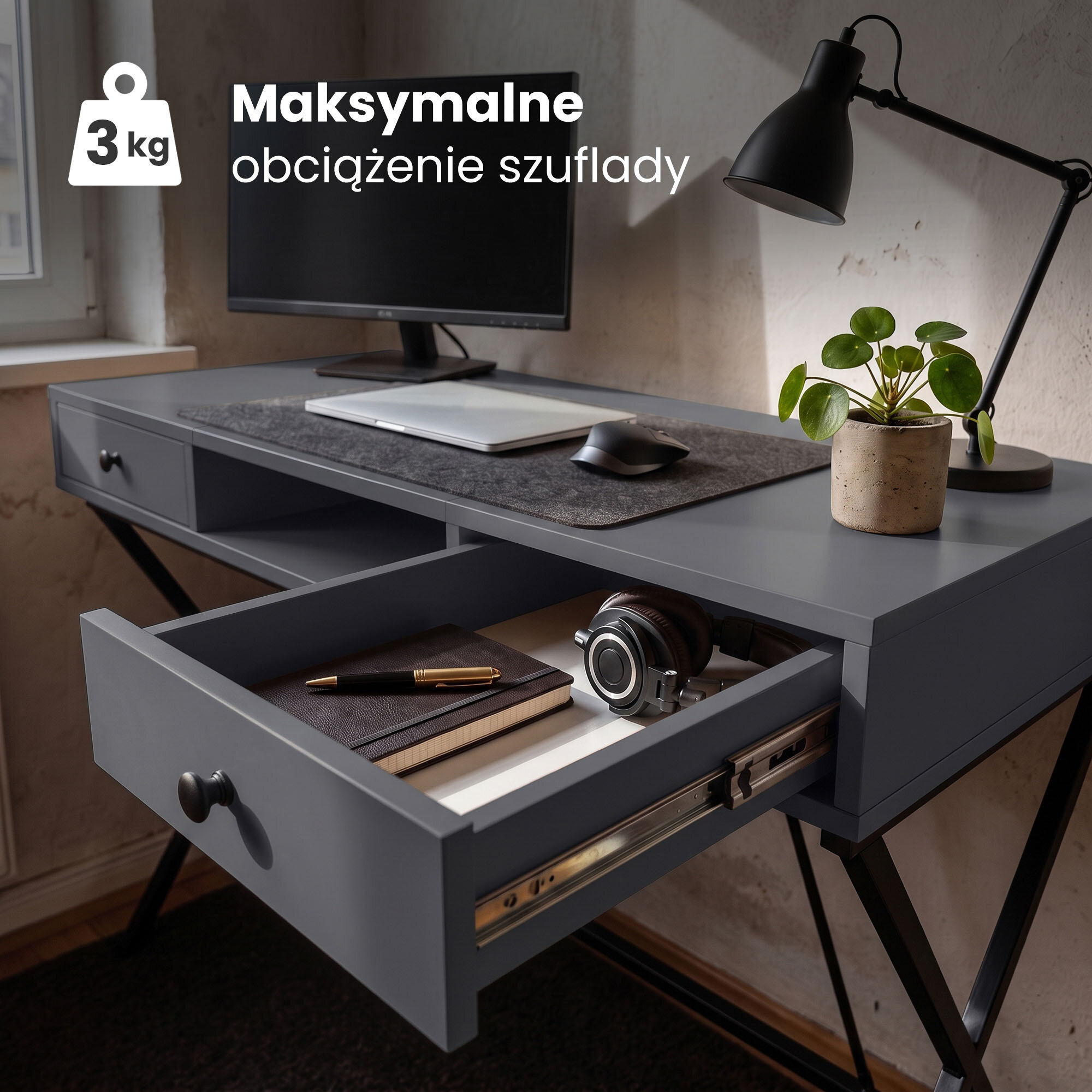 Biurko w stylu industrialnym z grafitowym blatem, czarnymi nogami, otwartą szufladą z książką i aparatem oraz lampką i rośliną na blacie. Tekst na obrazie: \'Maksymalne obciążenie szuflady 3 kg\'.