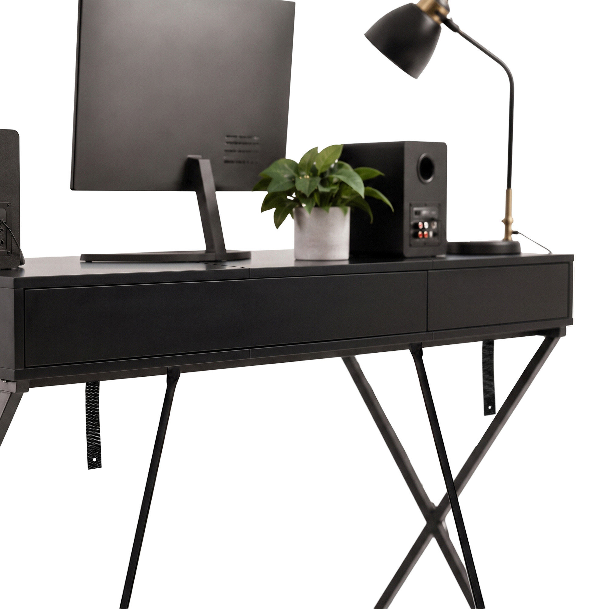 Czarne biurko o industrialnym designie z dwoma szufladami i jedną półką, na którym znajduje się monitor, roślina w doniczce, głośnik i lampa biurkowa.