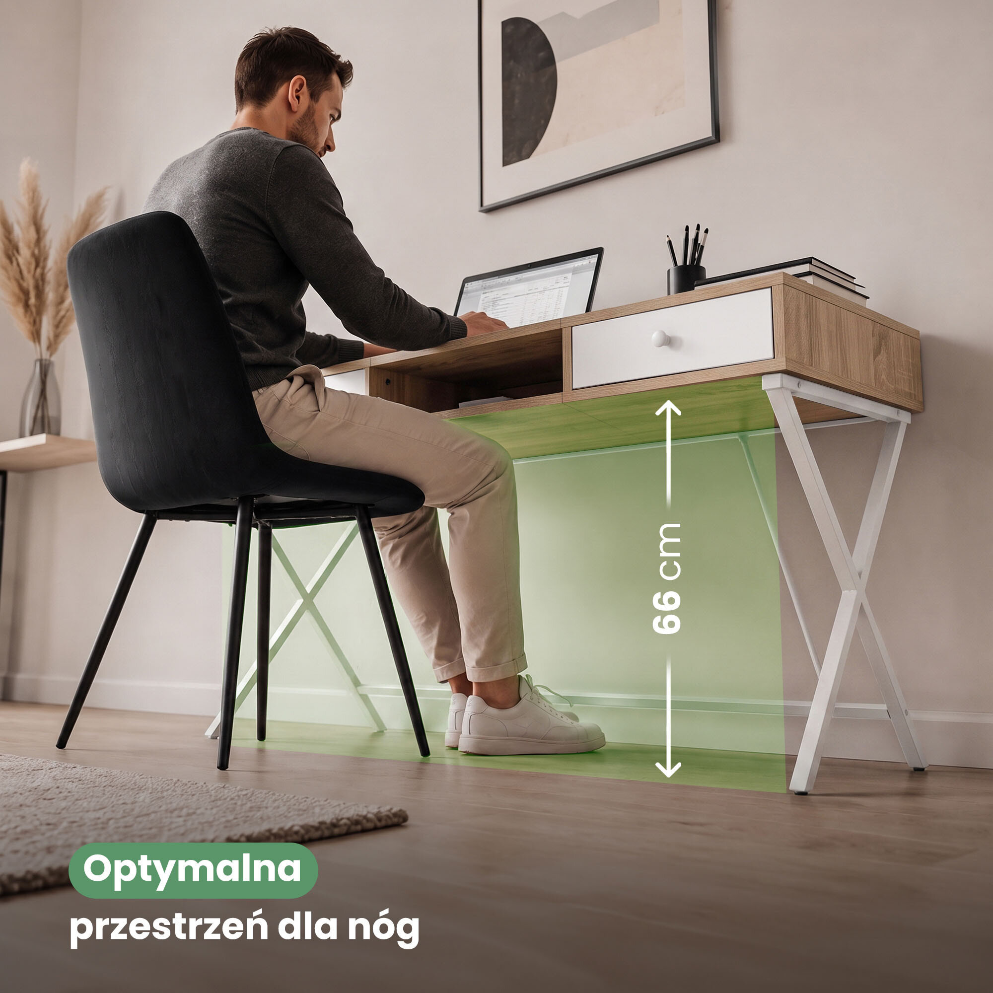 Mężczyzna siedzi przy biurku z laptopem, które ma drewniany blat i białe nogi w kształcie krzyża. Na obrazie widoczny jest tekst: \'Optymalna przestrzeń dla nóg\' oraz oznaczenie wysokości 66 cm.