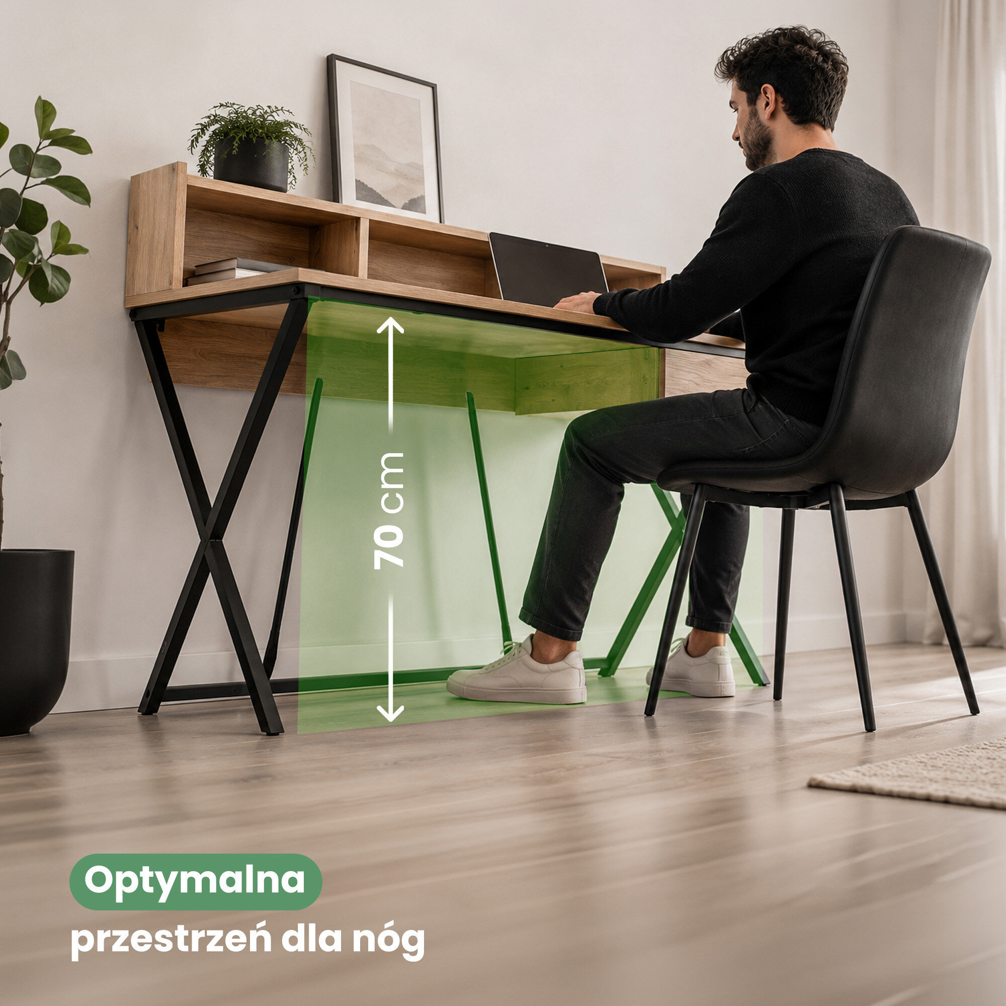 Osoba siedzi przy biurku z drewnianym blatem i czarnymi nogami, na którym znajduje się laptop. Na obrazie widoczny jest tekst: \'Optymalna przestrzeń dla nóg\' oraz oznaczenie wysokości 70 cm.